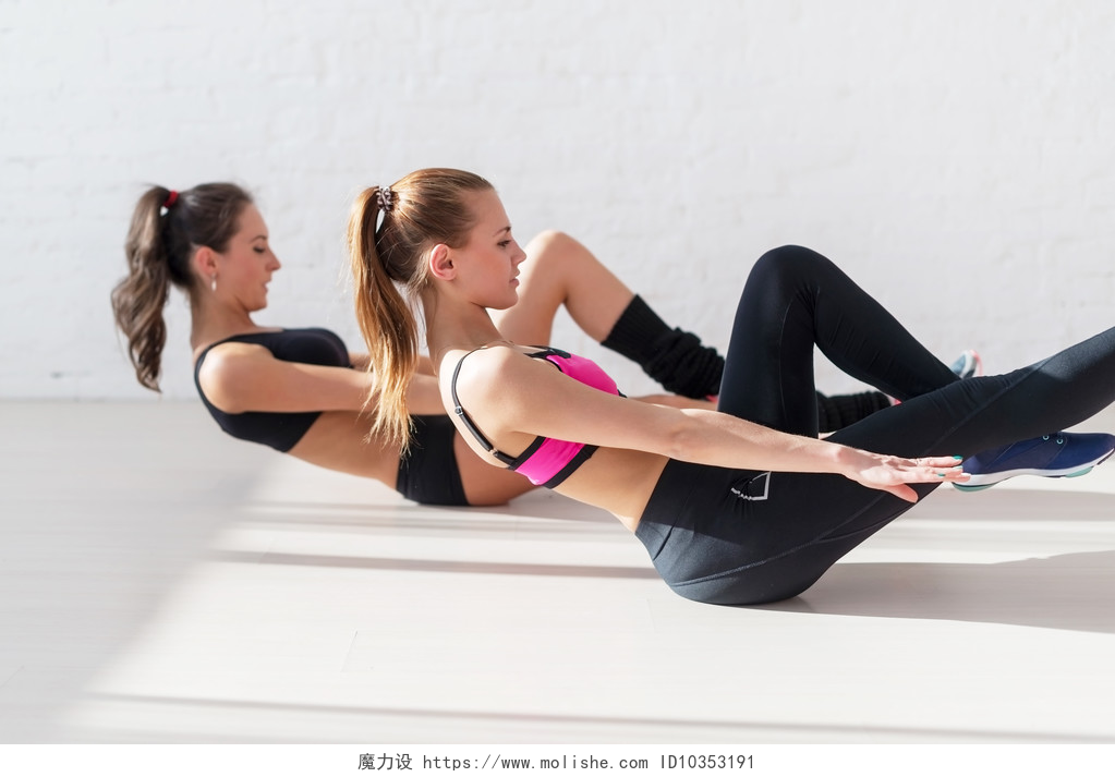 两个在健身房运动的女人两个运动妇女做锻炼腹肌练习，在健身房概念培训锻炼锻炼健身有氧侧视图地板上抽的新闻